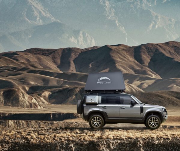 Black roof top tent on Land Rover Discovery in mountain range